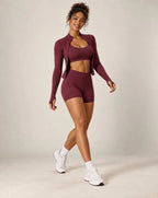 Burgundy sports bra and biker shorts workout set with long-sleeve layer