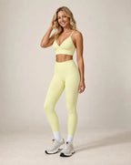 Light yellow high-waist fitted workout leggings with ankle-length leg cuffs
