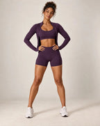 Purple sports bra and biker shorts workout set with long-sleeve layer