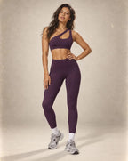 Purple sports bra and high-waist leggings set with white under-ankle stripe cuffs.
