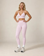 Light pink high-waist fitted workout leggings with ankle-length leg cuffs