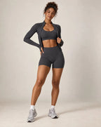 Dark gray sports bra and biker shorts workout set with long-sleeve layer