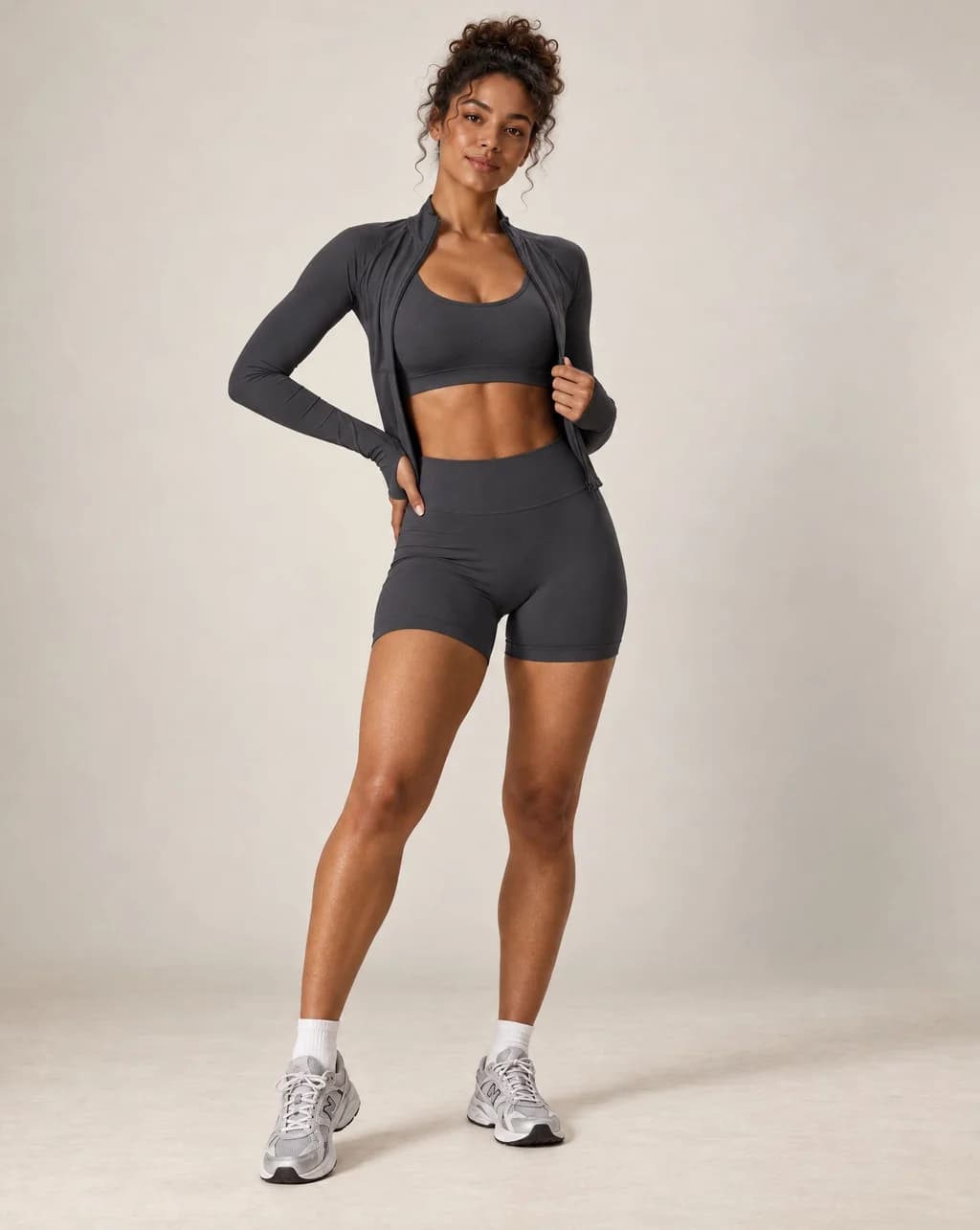 Dark gray sports bra and biker shorts workout set with long-sleeve layer