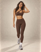 Brown sports bra and high-waist leggings set with crisscross cutout neckline.