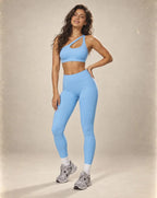 Light blue sports bra and high-waist leggings set with matching contrast strap.
