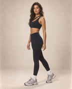 Black sports bra and high-waist leggings set with yellow stripe detail on straps.