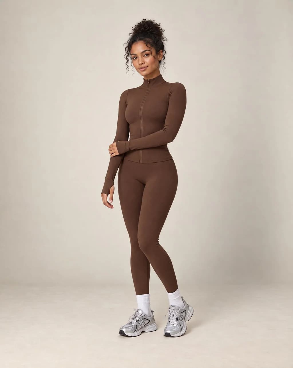 Brown zip-up workout jacket and matching leggings set with long sleeves and slim fit
