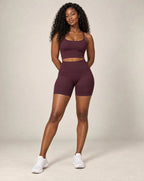 High-waist fitted yoga shorts, plum wine red, smooth stretchy fabric with mid-thigh length.