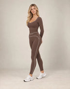 Brown long-sleeve slim-fit yoga top with contrast seam lines along the neckline and sides