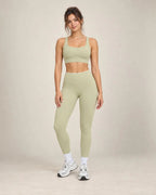 Light sage high-waisted yoga pants with white waistband and ankle-length legs