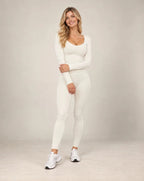 Cream long-sleeve slim-fit yoga top with contrast seam lines along neckline and sides