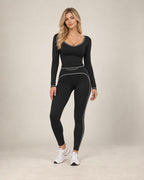 Black long-sleeve slim-fit yoga top with contrast piping around the scoop neckline